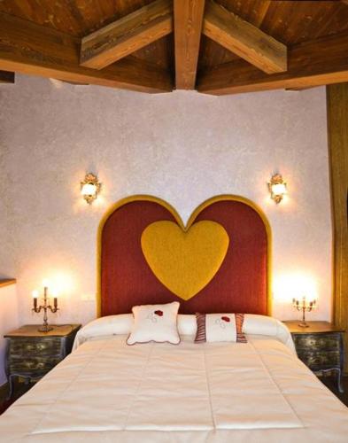 1 cama grande con un corazón pintado en la pared en El Carmen Exclusive, en Ávila