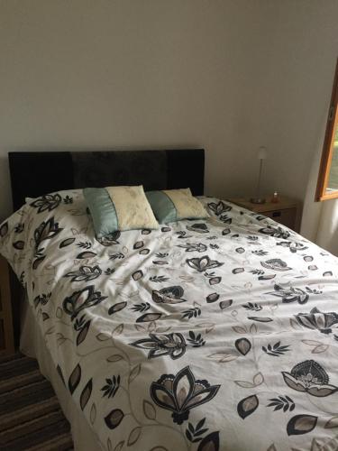 a large bed with a black and white comforter at Appartment tourmalet in Campan