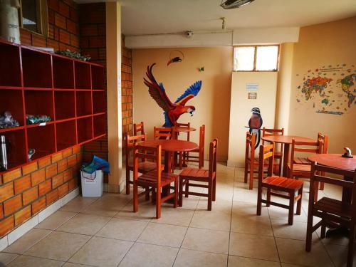 a restaurant with tables and chairs and a bird on the wall at El Mural Backpackers in Tarapoto