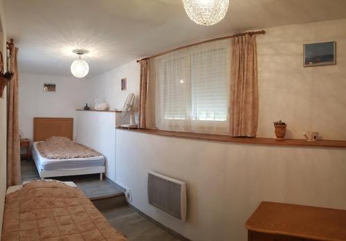 a bedroom with a bed and a window with a window at Chez Francine en bord de mer méditérrannée in Le Lavandou