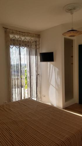 - une chambre avec un lit et une grande fenêtre dans l'établissement Macapa, à Mauléon