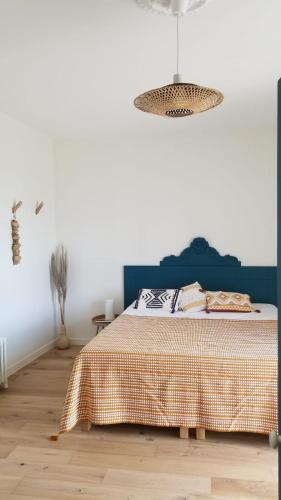 - une chambre avec un lit à tête bleue dans l'établissement Macapa, à Mauléon