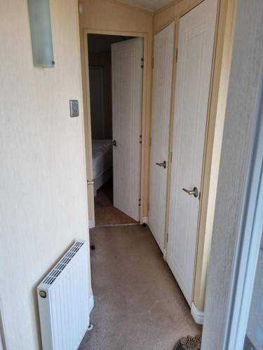 an empty hallway with two doors and a radiator at The Meridan Lodge - Close to beach - Swimming Pool & Amusements in Clacton-on-Sea