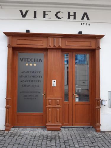a wooden entrance to a building with a sign on it at Apartmány Viecha in Bardejov
