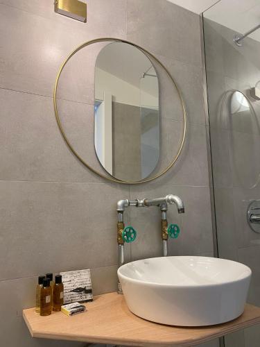 a bathroom with a white sink and a mirror at Castle Rhythm Inn in Arco