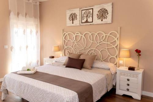 1 dormitorio con 1 cama grande con colcha blanca en La Casa de Silvia Visita Parque Warner, Madrid y alrededores en San Martín de la Vega
