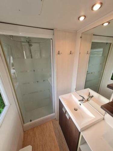 a bathroom with a sink and a large mirror at L'Orangerie de Lanniron - Mobil-Home O'HARA privilège - 3 chambres - 6 pers in Quimper
