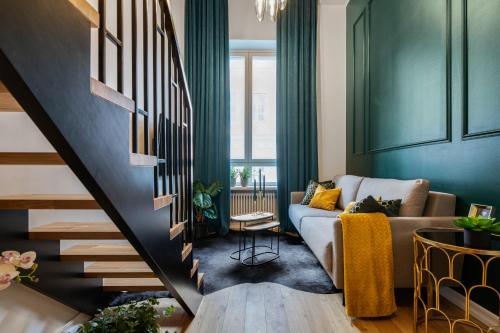 ein Wohnzimmer mit einem Sofa und einer Treppe in der Unterkunft Bob W Duo Lofts in Tartu