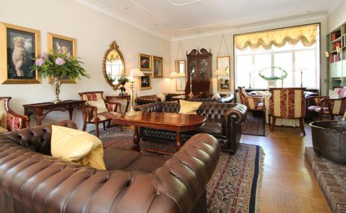 a living room with a leather couch and a table at Sauntehus Castle Hotel in Hornbæk