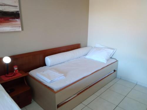 a small bed in a room with a small table at Amarilis Flat Apartament in Riviera de São Lourenço