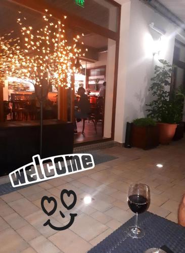 a glass of wine sitting on a table in front of a restaurant at Apartmány Viecha in Bardejov