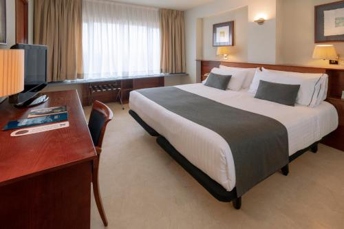 a hotel room with a large bed and a desk at Gran Hotel Rey Don Jaime in Castelldefels