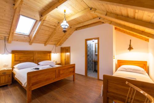 two beds in a room with wooden ceilings at Vintage Kuzina in Poljica
