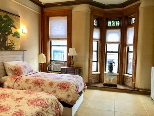 - une chambre avec 2 lits et des fenêtres dans l'établissement Northern Lights Mansion, à New York