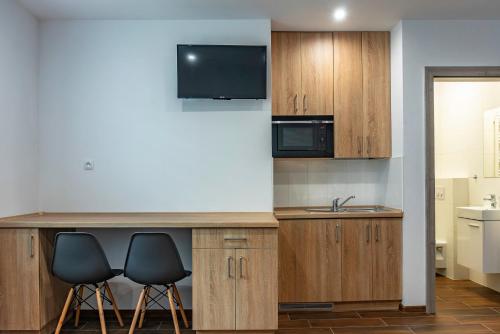 a kitchen with two chairs and a counter with a sink at Apartament Residence Nysa in Nysa