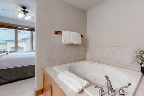 a white bathroom with a tub and a sink at Waterstone 2748 in Steamboat Springs