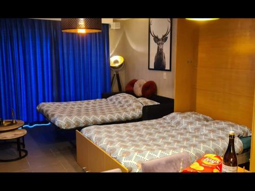 - 2 lits dans une chambre dotée de rideaux bleus dans l'établissement Enjoy Durbuy 4, à Durbuy