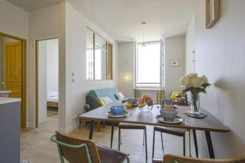 a kitchen and dining room with a table and chairs at Charming 1br flat with sea view at the heart of Biarritz - Welkeys in Biarritz