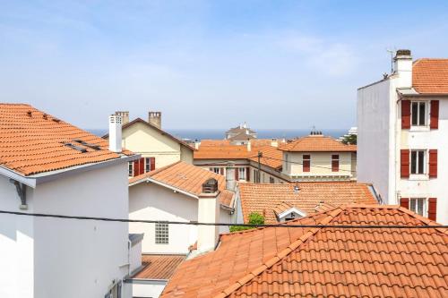 a view of roofs of buildings in a city at Charming 1br flat with sea view at the heart of Biarritz - Welkeys in Biarritz