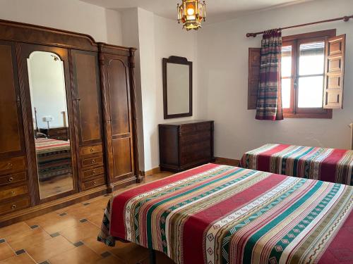 a bedroom with a bed and a dresser and a mirror at Hostal Rural Poqueira in Capileira