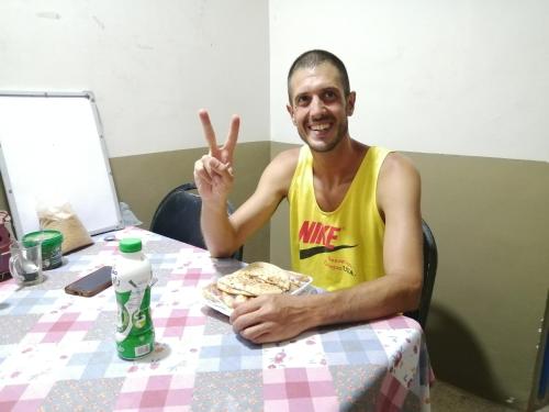 a man sitting at a table with his peace sign at david hostel in Aswan