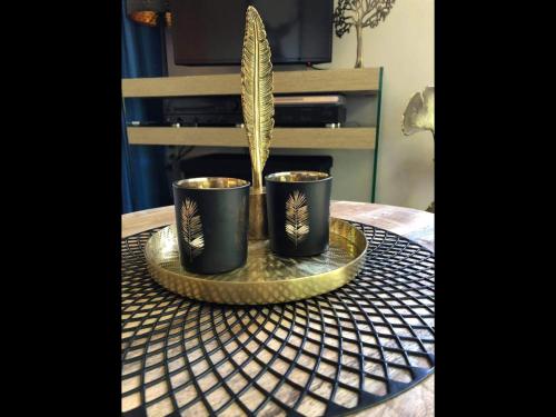 two black cups on a tray on a table with a plant at Enjoy Durbuy 4 in Durbuy
