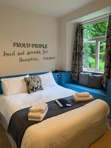 a bedroom with a bed with towels on it at Black Bull Inn in Haworth