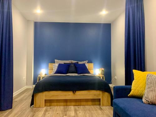 ein blaues Schlafzimmer mit einem Bett und einer blauen Wand in der Unterkunft 1 комнатная Квартира с великолепным видом на Красноярск и Енисей рядом с центром in Krasnojarsk