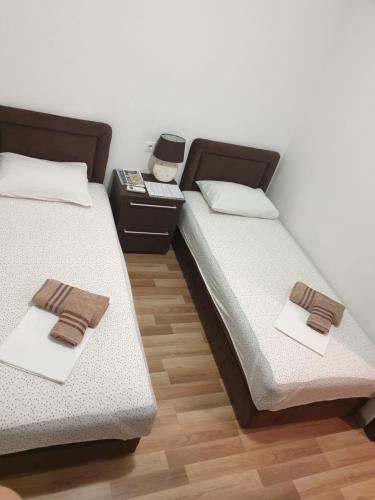 two beds sitting next to each other in a room at Nova dvokrevetna soba sa dva odvojena kreveta i zajedničkim kupatilom in Kotor