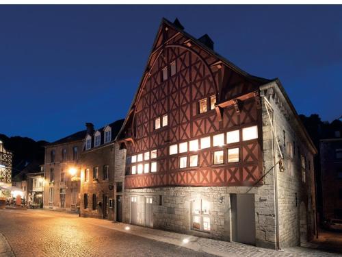 an old building with lit windows on a street at night at Enjoy Durbuy 4 in Durbuy