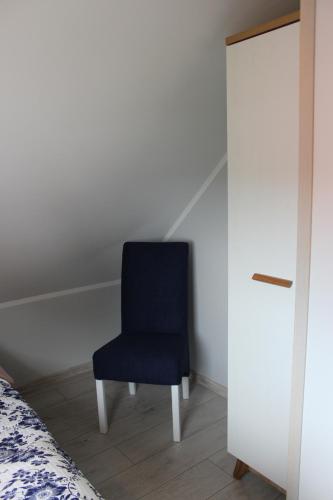 a blue chair sitting in a room next to a bed at Domki Niesiołowice in Niesiołowice