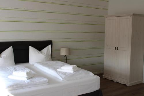 a bed with white sheets and pillows on it at Spreezeit Hotel connect in Senftenberg