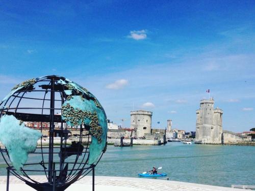 un globe en face d'un château dans l'eau dans l'établissement Nuit insolite sur un bateau - Linge & ménage inclus, à La Rochelle