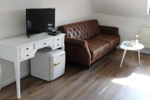 a living room with a couch and a tv and a table at Spreezeit Hotel connect in Senftenberg