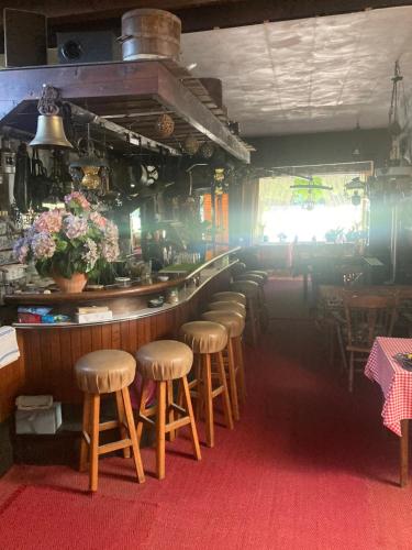 a row of stools at a bar in a restaurant at Bed and Breakfast in Zilk