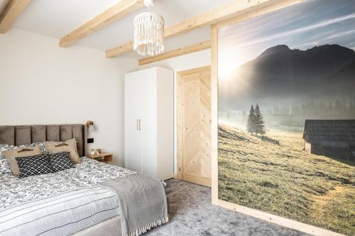 a bedroom with a sliding barn door with a picture on the wall at Folkova 21 - Apartamenty in Biały Dunajec