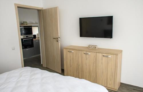 a bedroom with a bed and a television on a wall at apart bun in Oradea