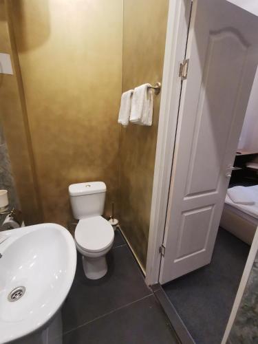 a bathroom with a white toilet and a sink at Hotel Kārklu Muiža in Jelgava