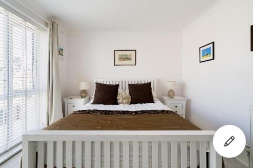 1 dormitorio blanco con 1 cama grande y 2 mesitas de noche en Viking Bay House en Broadstairs
