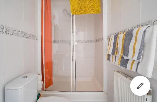 a white bathroom with a shower and a toilet at Viking Bay House in Broadstairs