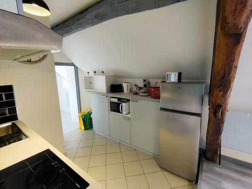a kitchen with a stainless steel refrigerator and appliances at La Machine Sous Toit in La Machine