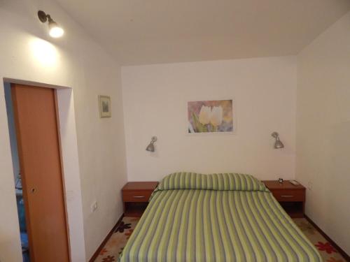 a bedroom with a green bed and two night stands at Apartment Tomato in Pula