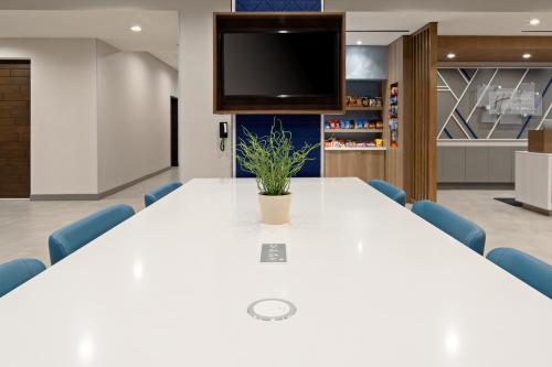 a conference room with a large white table and blue chairs at Holiday Inn Express & Suites - Valencia - Santa Clarita by IHG in Valencia