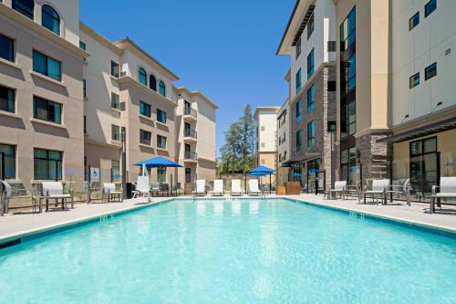 a swimming pool in the courtyard of a apartment building at Holiday Inn Express & Suites - Valencia - Santa Clarita by IHG in Valencia