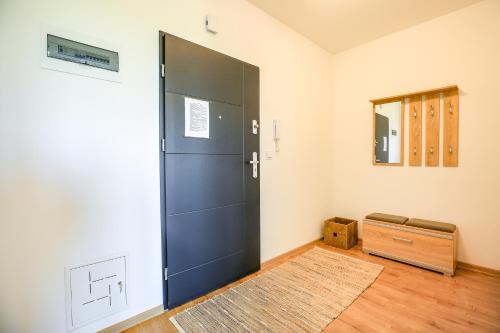 a large black door in a room with a rug at Apartament Comfort in Suwałki