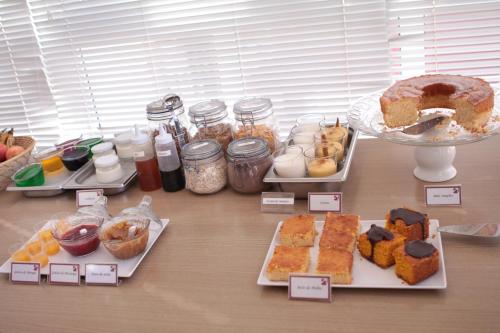 a table topped with different types of food on plates at Hotel Copacabana Piracicaba in Piracicaba