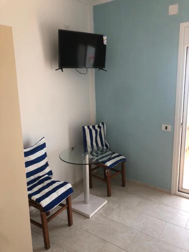 a room with a table and two chairs and a tv at Villa John in Borsh