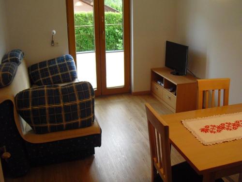 a living room with a table and a chair and a television at Haus Grünbacher in Lienz