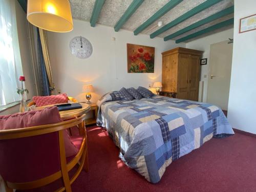 a bedroom with a bed and a table and a chair at Hotel & Restaurant De Fortuna in Edam