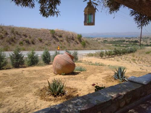 a large pot sitting on the side of a road at Paliokaliva Home in Roussopoúlion